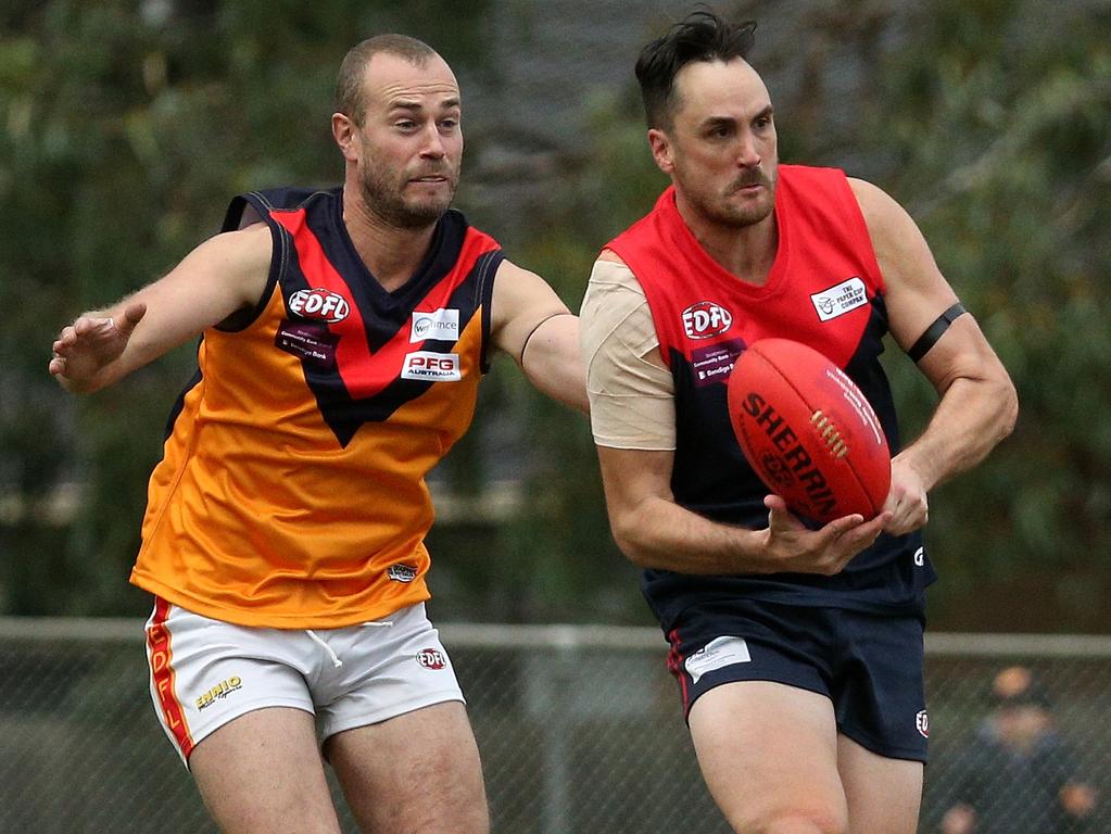 Essendon District: Tullamarine’s Bradley Allen dishes off under pressure against East Keilor. Picture: Hamish Blair