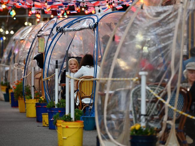 TOPSHOT - People dine in plastic tents for social distancing at a restaurant in Manhattan on October 15, 2020 in New York City, amid the coronavirus pandemic. (Photo by Angela Weiss / AFP)