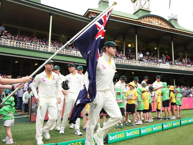 Australian captain Steve Smith grabs the Australian flag as he leads out the team during the opening day of the fifth Ashes Test at the SCG this year.