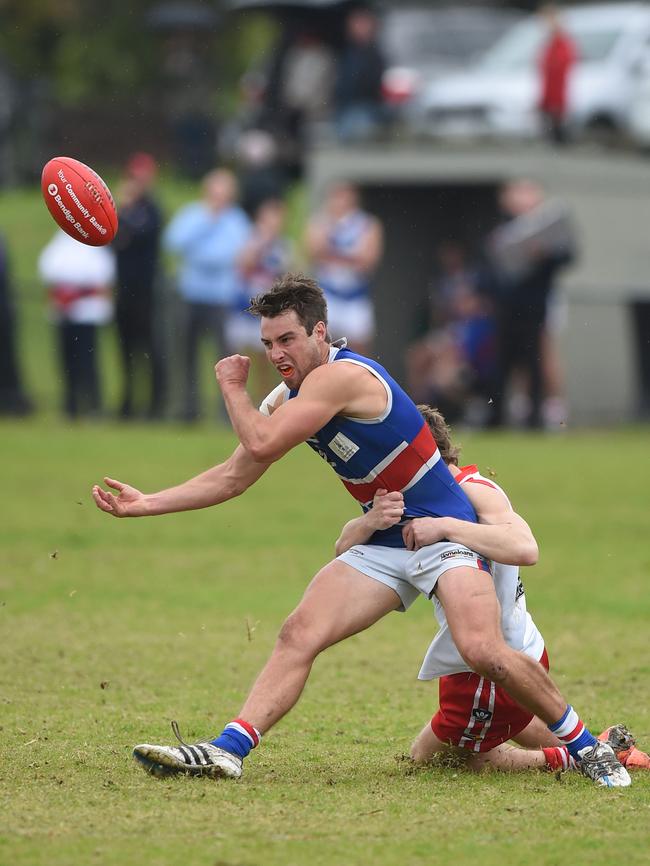 Mornington’s Joel Miller handballs under pressure against Karingal. Picture: Chris Eastman