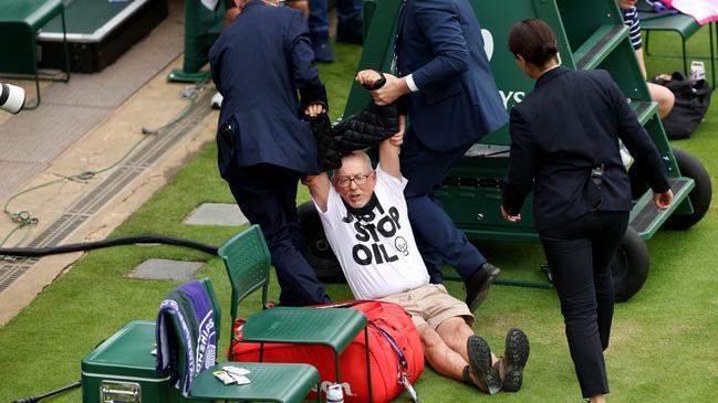 Officials drag the Wimbledon protester off the court. Picture: Getty Images