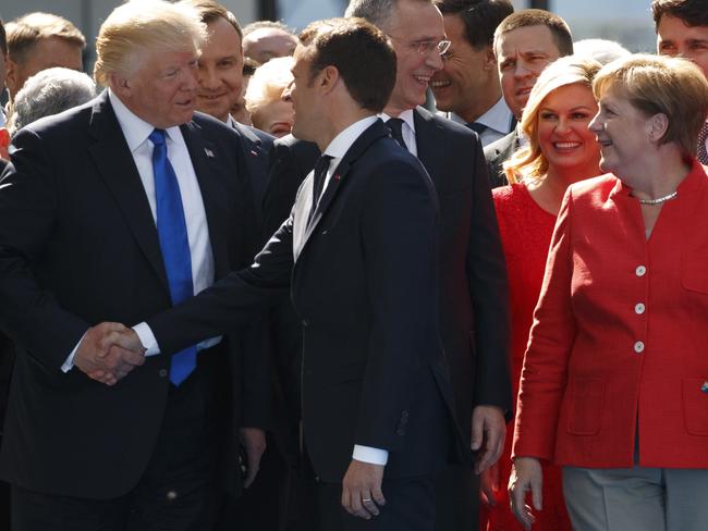 German Chancellor Angela Merkel watches as President Donald Trump shakes hands with French President Emmanuel Macron. Picture: AP Photo/Evan Vucci