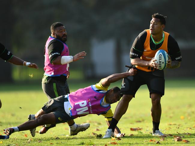 Israel Folau of Australia is tackled by Will Genia of Australia during an Australia training session at the Lensbury Hotel.