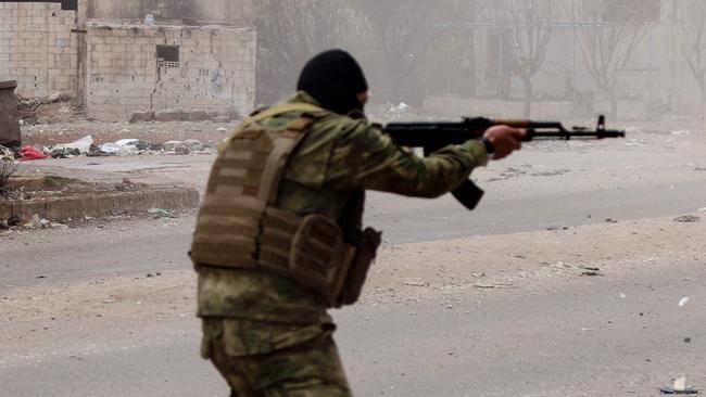 A member of Syria's new authorities security forces fires his weapon in Sanamayn, in the southern province of Daraa, during a reported large scale military campaign on March 5, 2025. Syria has seen clashes and shootings in a number of areas, often blamed on Assad supporters, with the new authorities announcing campaigns targeting "regime remnants" and making arrests. (Photo by Bakr ALKASEM / AFP)