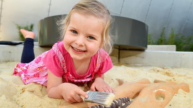 Three-year-old Sophie with a dinosaur skeleton in the museum’s sandpit. Picture: Josie Hayden