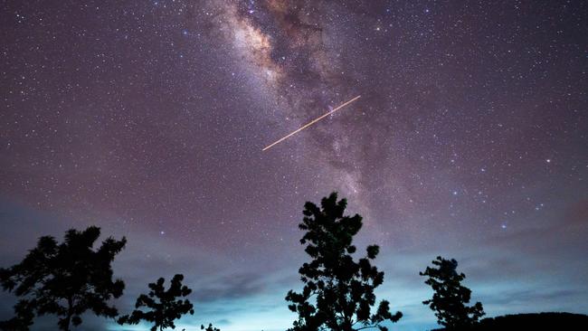 A flight-illuminated path and the Milky Way are appearing in the night sky during the Eta Aquarids meteor shower, which is peaking in Ratnapura, Sri Lanka, on May 5, 2024. The Eta Aquarids Meteor Shower is an annual event caused by Earth passing through debris left behind by Halley's Comet. Named after the constellation Aquarius, these meteors are streaking across the sky at high speeds, creating a dazzling display of shooting stars. Best observed in the predawn hours away from city lights, it is a mesmerizing celestial event cherished by skywatchers worldwide. (Photo by Thilina Kaluthotage/NurPhoto via Getty Images)