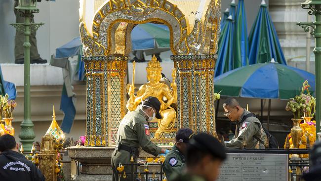 Police investigators work near the statue of Phra Phrom after the explosion at Erawan Shrine. Picture: AP