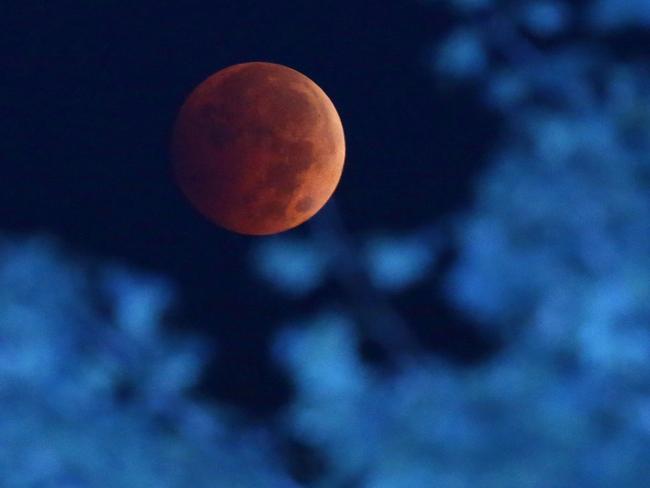 The Earth’s shadow renders the moon during a total lunar eclipse over Milwaukee. Picture: AP