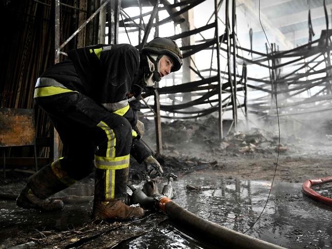 A Ukrainian firefighter works to put out fire in a shopping mall following a Russian shelling in Kherson. Picture: AFP