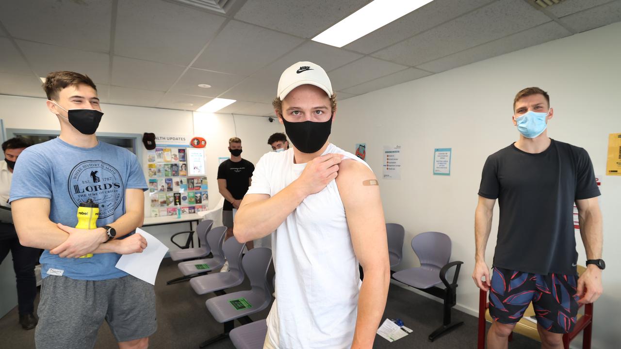 St Kilda players Cooper Sharman, Jack Billings and Mason Wood wait in the recovery area after their jab. Picture: David Caird.