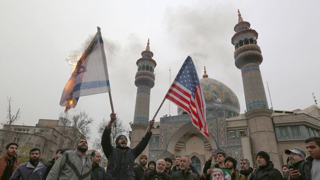 Iranians burn an Israeli and US flag during an anti-American protest in Tehran.