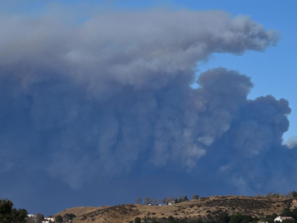 A plume of smoke from the new Hughes fire is seen behind the California State Route 14 highway from Santa Clarita. Picture: AFP