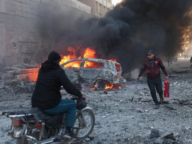 People try to extinguish fires following an air strike that targeted Syria's rebel-held northern city of Idlib. Picture: AFP