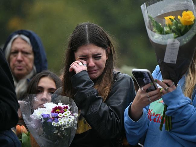 Crying fans of former One Direction singer Liam Payne gather with flowers beside the Peter Pan statue in Kensington Gardens, adjacent to Hyde Park. Picture: AFP