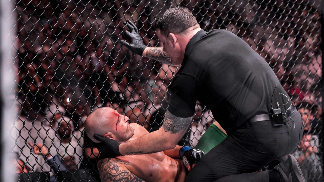 An official checks on Australia's Alexander Volkanovski. Picture: AFP