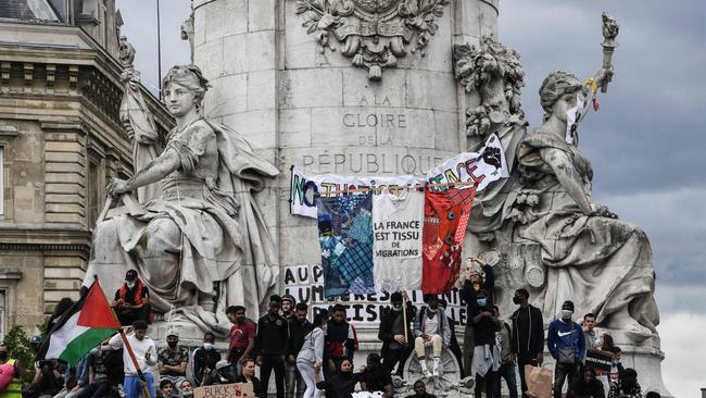 Protesters stand on the statue of Marianne on Place de la Republique in Paris during a Black Lives Matter protest.