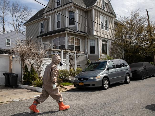 YONKERS, NEW YORK - APRIL 14: (EDITORIAL USE ONLY) A Yonkers Fire Department EMT, clothed in full personal protective equipment (PPE), walks back to his truck after helping carry a patient with COVID-19 symptoms out of her house for transport to a hospital on April 14, 2020 in Yonkers, Westchester County, New York. Different emergency services, even within the same cities, follow varying PPE levels while responding to potential COVID-19 calls. Located adjacent to New York City, Westchester County is considered part of the epicenter of the coronavirus pandemic in the United States.   John Moore/Getty Images/AFP