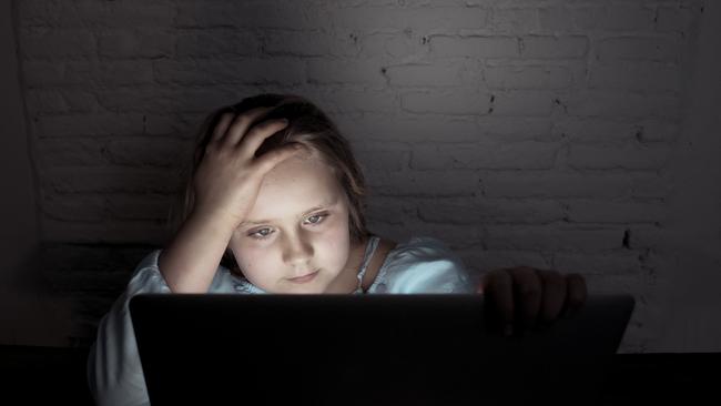 Scared sad girl bullied online on laptop suffering cyber bullying harassment. School girl humiliated on the internet by classmates feeling desperate and intimidated. Children victim of bullying.