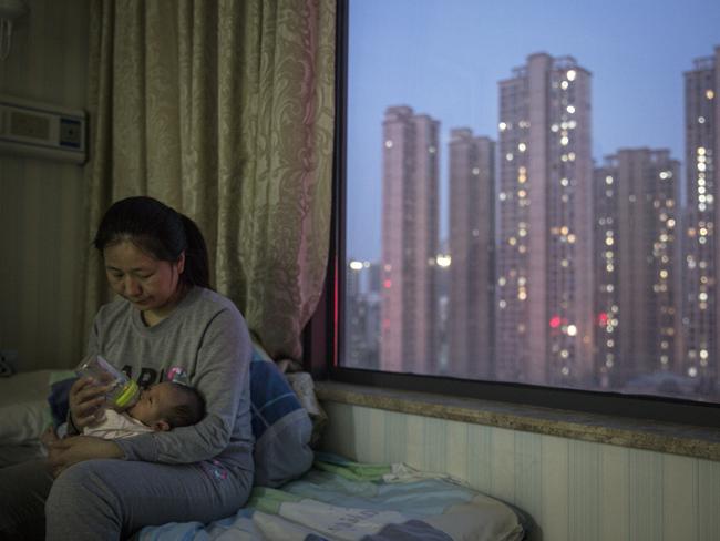 A maternity nurse wears a mask as she bottle-feeds a newborn at a private hospital in Wuhan, China. Picture: Getty Images