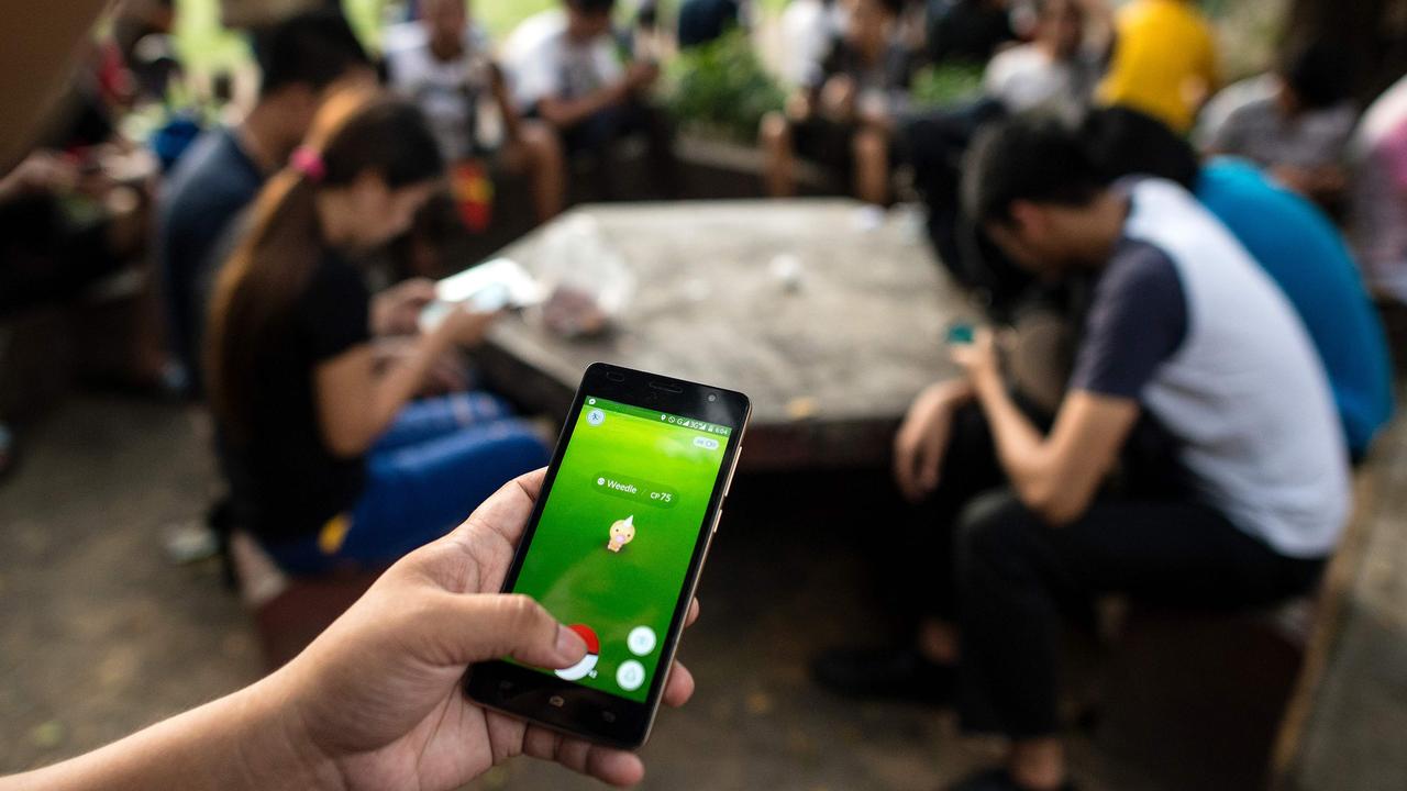 Millions of people around the world have been glued to their smartphones playing the virtual game. Picture: AFP Photo / Noel Celis.