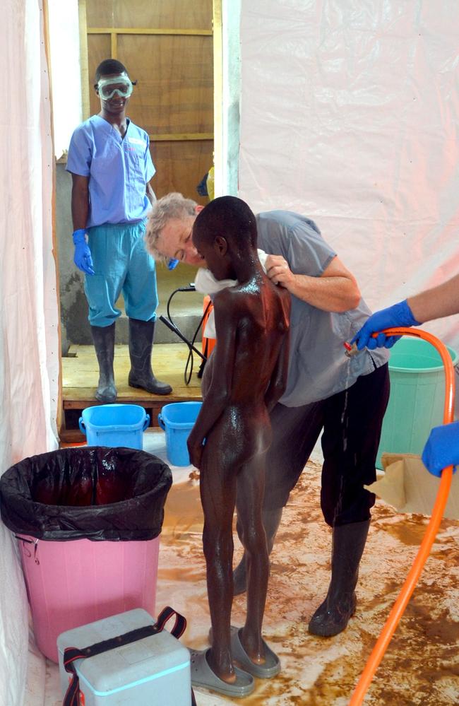 A 10-year-old boy is showered after being taken out of quarantine following his mother's death caused by the ebola virus.