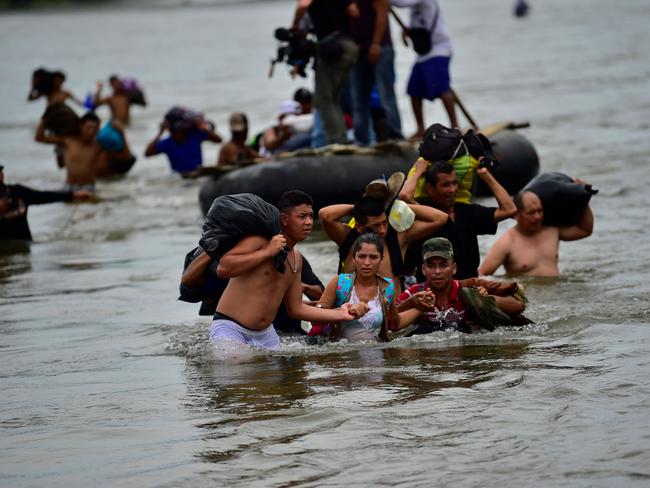 Honduran migrants heading in a caravan to the US, arrive in Ciudad Hidalgo, Chiapas state, Mexico after crossing the Suchiate River from Guatemala, on October 20, 2018. - Thousands of migrants who forced their way through Guatemala's northwestern border and flooded onto a bridge leading to Mexico, where riot police battled them back, on Saturday waited at the border in the hope of continuing their journey to the United States. (Photo by Pedro Pardo / AFP)