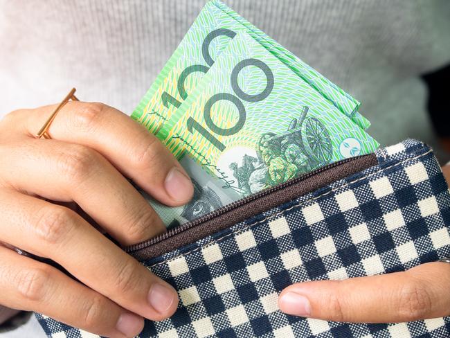 Woman put dollar australia money into wallet.