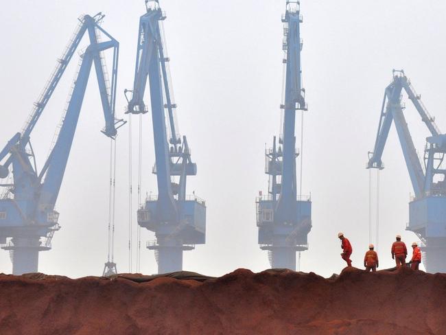 China’s steel sector is demanding ore imports with higher iron content, leading to pile-ups in port cities of lower-grade imports. Shown, workers prepare ore from Australia to be transported from a port in Tianjin. PHOTO: VINCENT DU/REUTERS