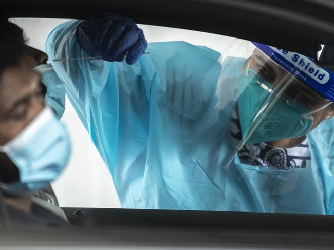 *** BESTPIX *** SYDNEY, AUSTRALIA - JANUARY 07: A health worker carries out a COVID-19 testing at the Merrylands drive-through clinic on January 07, 2021 in Sydney, Australia. NSW Health authorities continue to work to contain the current coronavirus outbreak across NSW as new positive COVID-19 cases and exposure venues continue to be confirmed. Facemask are now compulsory in NSW on public transport and certain indoor settings such as retail  and shopping centres. (Photo by Brook Mitchell/Getty Images)