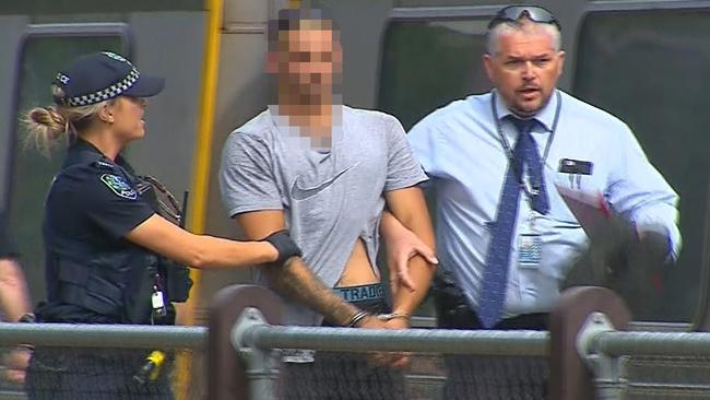 Antoni Barresi, accused of stabbing a French national at Belair National Park is taken from Belair Rail Station by police. Picture: Nine News