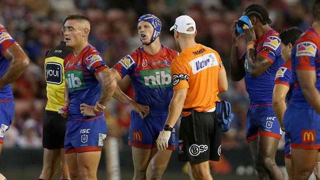 The Knights’ orange-shirt trainer in conversation with Kalyn Ponga. So which is it, injury, interchange or water? Picture: Ashley Feder/Getty Images