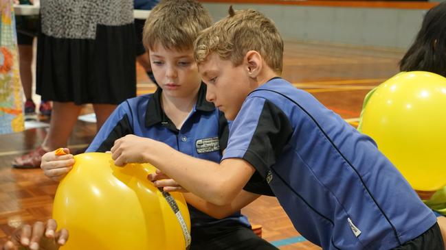 Felix and Jack from Howard Springs Primary School measuring circumference of the balloons as part of an exercise to teach about diameter at the Meaningful Maths day. Picture: Department of Education and Training NT