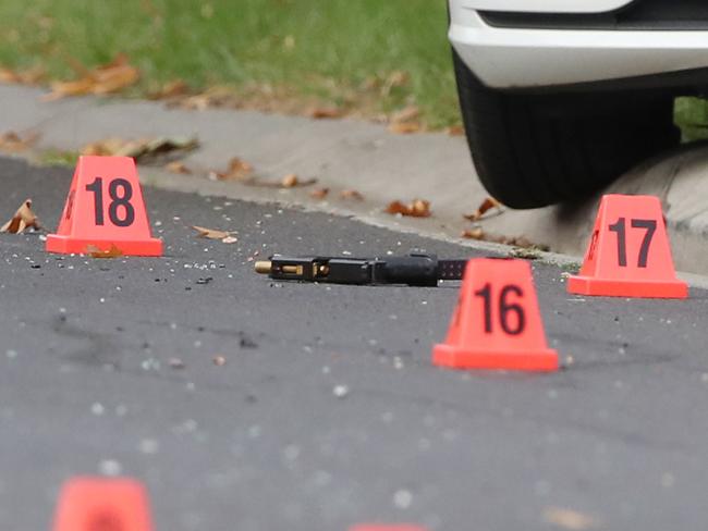 Markers around a gun and bullet casings. Picture: David Crosling