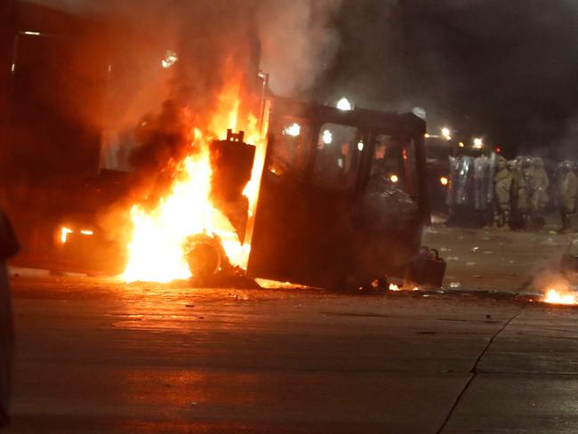 Kenosha County Sherriff and police officers in riot gear form a line behind a burning truck during demonstrations against the shooting of Jacob Blake in Kenosha, Wisconsin on August 24, 2020. - Police faced off with hundreds of peaceful protesters ahead of a curfew in this city in Wisconsin Monday, as rage grew once more in the US at the shooting of a black man by a white officer. (Photo by KAMIL KRZACZYNSKI / AFP)