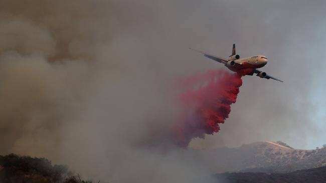 A firefighting aircraft dropping retardant ahead of the Palisades fire. Australia has invested $48m to secure a LAT and three heavy-lift-helicopters but this is still below the seven LATs needed. Picture: Justin Sullivan/Getty Images/AFP