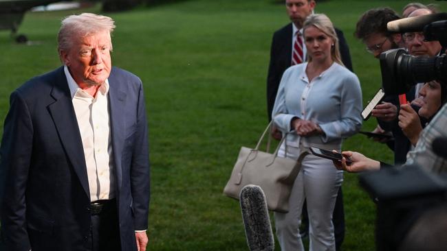 White House Press Secretary Karoline Leavitt watches as Donald Trump takes questions from the press on the South Lawn of the White House. Picture: AFP