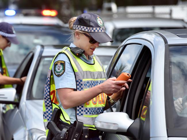 ** WARNING - POLICE OFFICER HAS ASKED FOR NAME NOT TO BE PUBLISHED AS IT MAY JEOPARDISE A FUTURE APPOINTMENT. PLEASE USE GENERIC CAPTION ** Senior Constable Jessica Brooks (R) conducts a breath alcohol test on Matt Salmon during a RBT operation at Terrigal on Tuesday 27th March 2018. Police will be out in force across the Central Coast over the Easter long weekend. (AAP IMAGE / Troy Snook)