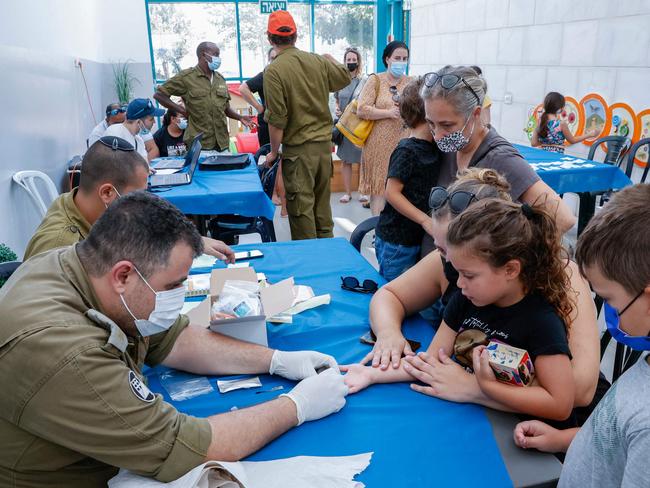 Israeli children undergo Covid-19 antibody testing in the coastal city of Netanya on August 22, 2021, before the start of the new school year. - Israel launched antibody testing for children aged as young as three, seeking information on the number of unvaccinated youths who have developed protection against coronavirus ahead of the new school year, in order to avoid the hardships and developmental setbacks caused by school closures. (Photo by JACK GUEZ / AFP)