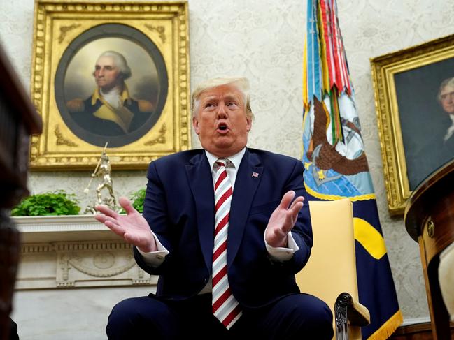 U.S. President Donald Trump answers questions while sitting in front of paintings of former U.S. presidents George Washington and Thomas Jefferson during his meeting with Romania's President Klaus Iohannis in the Oval Office of the White House in Washington, U.S. August 20, 2019. REUTERS/Kevin Lamarque TPX IMAGES OF THE DAY - RC1F59ABB150