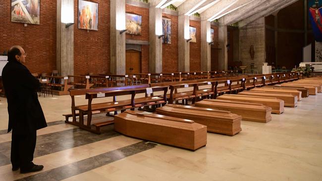 Parish priest of Seriate, Don Mario stands by coffins stored into the church of San Giuseppe in Seriate, near Bergamo, Lombardy, in March. Picture: AFP