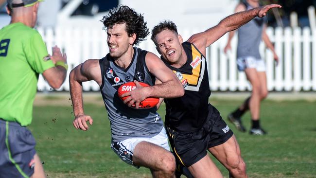 Adelaide University midfielder Ryan Marini evades Brighton’s Nigel Osborn during Adelaide Footy League division one match earlier this season. Picture: Brenton Edwards