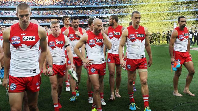 Dejected Sydney players leave the field as Hawthorn celebrate winning the 2014 grand final. Picture: Phil Hillyard