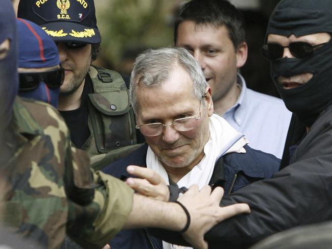 FILE - In this file photo dated Tuesday, April 11, 2006, Mafia boss Bernardo Provenzano is escorted by police security as he enters a Police building in Palermo, Italy, after being arrested. The European court of human rights in Strasbourg ruled Thursday Oct. 25, 2018, that Italy violated the rights of the late Mafia "boss of bosses" Provenzano by maintaining strict anti-Mafia prison conditions in his last few months alive, and the ruling provoked an immediate rebuke from Italian Deputy Premier Luigi Di Maio, who said "the inhumane behaviors were those of Provenzano." (AP Photo/Luca Bruno, FILE)