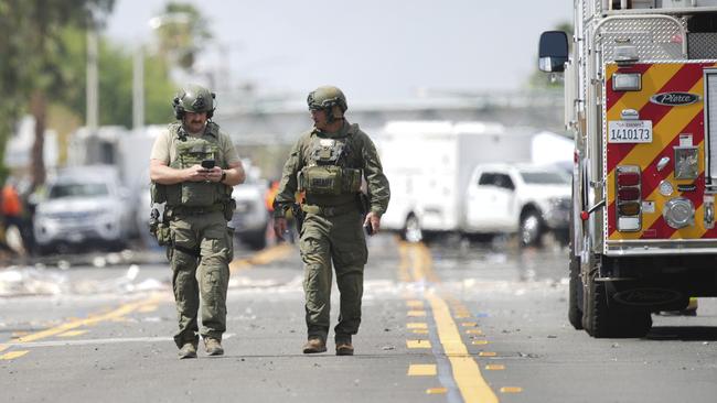 Sheriffs deputies walk near the scene of an explosion Saturday, May 17, 2025, in Palm Springs, Calif. (AP Photo/Eric Thayer)