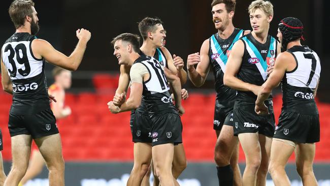 CELEBRATION TIME: Port Adelaide players celebrate their round one win against Gold Coast at Metricon Stadium. Picture: CHRIS HYDE (Getty Images).