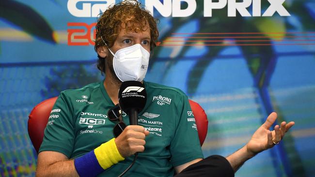 Aston Martin's German driver Sebastian Vettel speaks at a press conference as he wears Ukraine wrist band