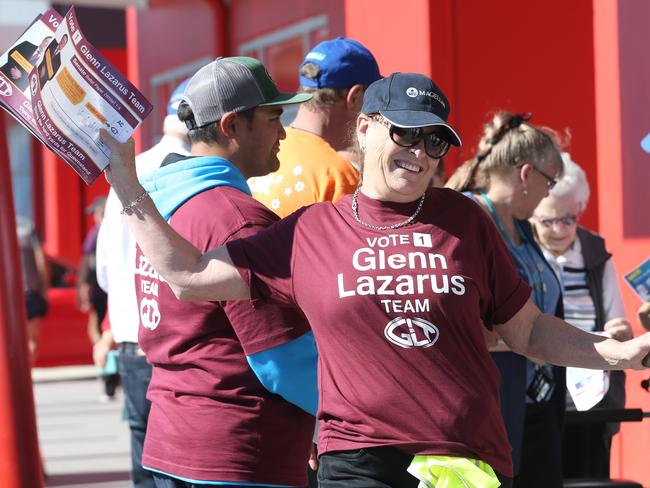 Party volunteers hands out how to vote cards to voters outside the polling station in Oxenford, Gold Coast.