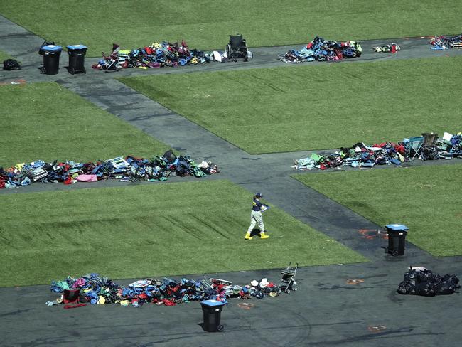 A member of the FBI walks among piles of personal items at the scene. Picture: AP