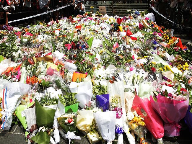SYDNEY, AUSTRALIA - DECEMBER 16: Flowers are left as a sign of respect at Martin Place on December 16, 2014 in Sydney, Australia. The siege in Sydney's Lindt Cafe in Martin Place is over after 16 hours. Police raided the cafe just after 2am AEDT on Tuesday morning. Three people have been confirmed killed, two hostages and the gunman. (Photo by Mark Metcalfe/Getty Images)