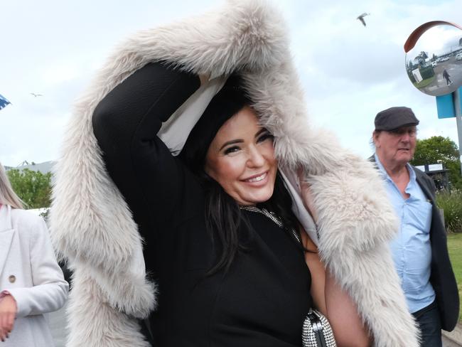 Cara SpangaroIn was among the people the aftermath of the Geelong Cup shielding themselves from the wet weather. Picture: Mark Wilson
